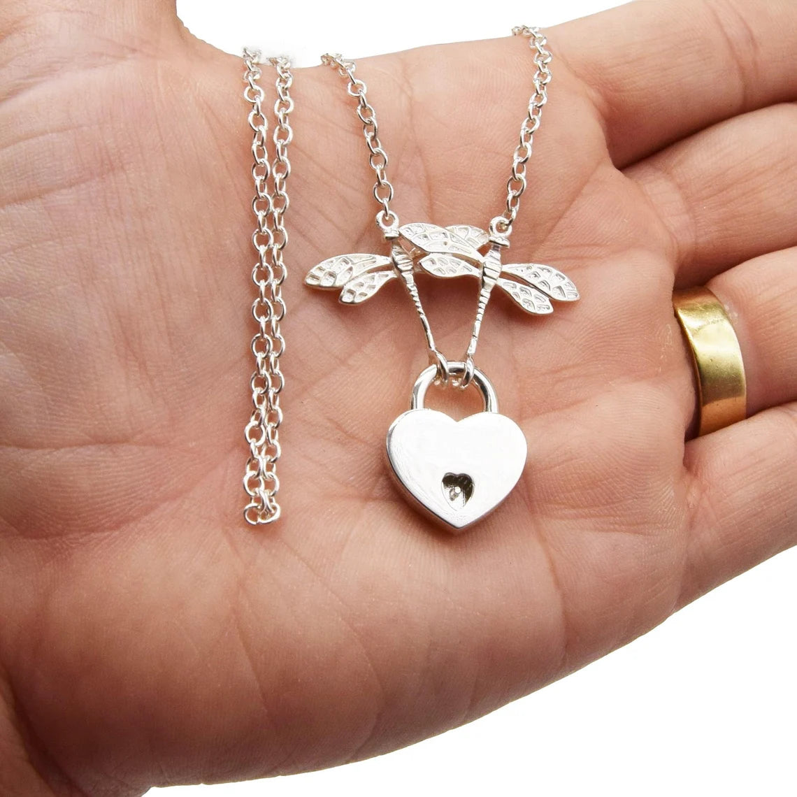 BDSM Locking Day Collar Jewelry Necklace with Lock and double dragonflies and options of O ring with large sterling bell available in solid 316L Stainless Steel or 925 sterling silver shown on a model's hand