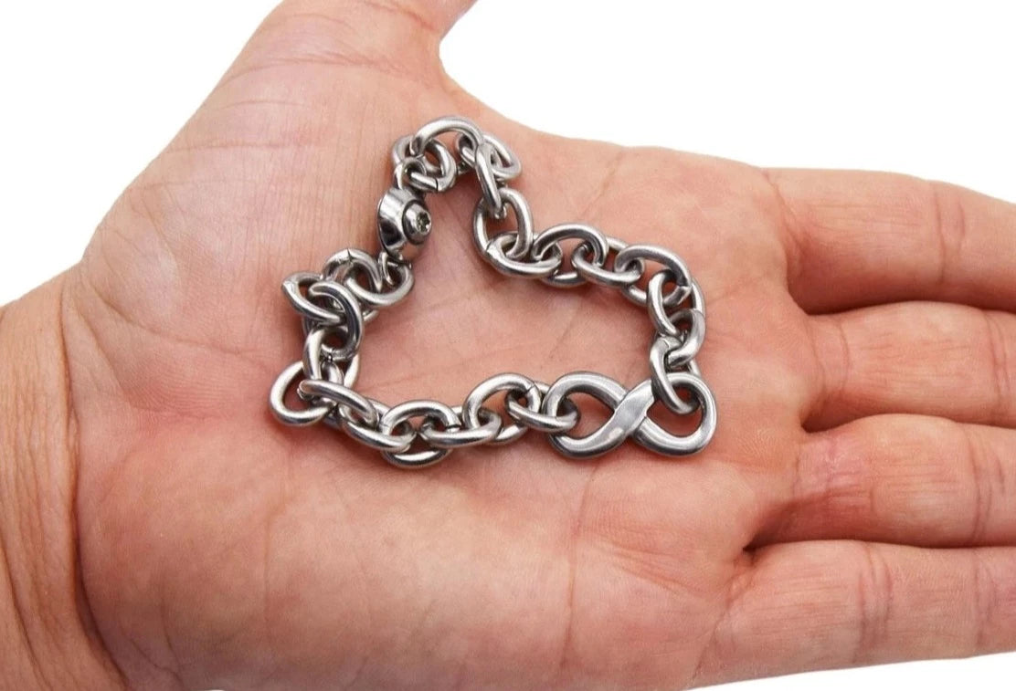 BDSM Locking Day Collar Jewelry wrist bracelet of Lock and O ring with large sterling bell available in solid 316L Stainless Steel or 925 sterling silver shown on a model's hand