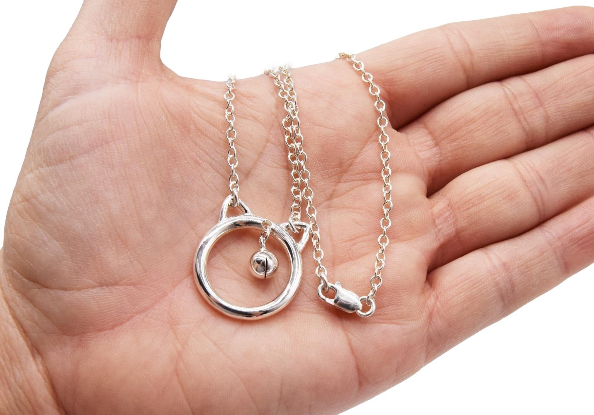 BDSM Locking Day Collar Jewelry Necklace of Lock and O ring with large sterling bell available in solid 316L Stainless Steel or 925 sterling silver shown on a model's hand